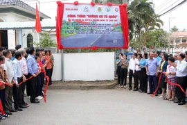 Ban tổ chức tiến hành nghi thức công bố biển công trình "Đường cờ Tổ quốc" tại xã Nhơn Ái, Phong Điền. (Ảnh: Trung Kiên/TTXVN)