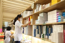Nhân viên y tế lấy thuốc để cấp phát cho người bệnh tại một bệnh viện. (Ảnh: PV/Vietnam+)
