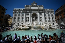 Khách du lịch giải nhiệt tại đài phun nước Barcaccia trong thời tiết nắng nóng gay gắt tại Rome, Italy, ngày 21/8/2023. (Ảnh: AFP/TTXVN)