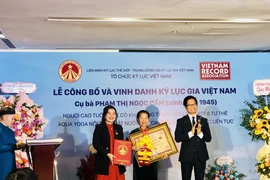 Tổ chức Kỷ lục Việt Nam (VietKings) trao bằng chứng nhận cho cụ bà Phạm Thị Ngọc Cầm. (Ảnh: Phương Hà/TTXVN)