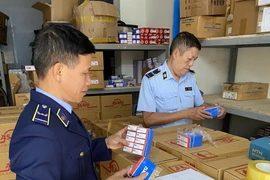 Lực lượng Quản lý Thị trường Hà Nội kiểm tra hàng hóa có dấu hiệu vi phạm. (Ảnh: PV/Vietnam+)