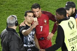 Ronaldo cố gắng cười khi chụp ảnh cùng người hâm mộ. (Nguồn: AFP/Getty Images)
