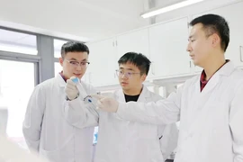Các nhà khoa học Trung Quốc xem xét mẫu thử nghiệm vaccine hít dạng bột tại phòng thí nghiệm tại Bắc Kinh. (Ảnh: THX)