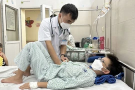 Bác sỹ thăm khám cho bệnh nhi đang điều trị tại Bệnh viện Đa khoa Xanh Pôn. (Ảnh: Minh Quyết/TTXVN)