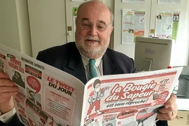 Tổng biên tập Jean d'Indy cầm ấn phẩm lần thứ 12 của báo La Bougie du Sapeur. (Nguồn: Le Point)