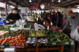 Người dân mua hàng tại một chợ ở Melbourne, Australia. (Ảnh: AFP/TTXVN)