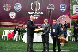 Tham tán Vũ Sơn Việt, Phó Trưởng ban công tác cộng đồng Đại sứ quán Việt Nam tại Nga (giữa) tặng hoa Ban tổ chức Sadovod League 2024. (Ảnh: Quang Vinh/TTXVN)