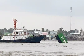 Vụ va chạm hàng hải giữa tàu INTERASIA PURSUIT (quốc tịch Singapore) với sà lan mang biển kiểm soát SG 8259 làm 9 container rỗng bị rơi xuống sông. (Ảnh: TTXVN phát)
