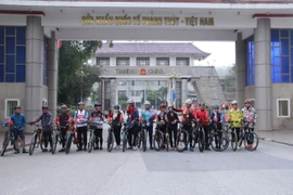 Du khách tham gia tour xe đạp “Một hành trình-Hai quốc gia” dừng chân ở cửa khẩu Thanh Thủy. (Ảnh: BTC)