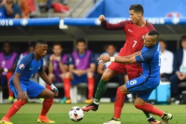 Hậu vệ Patrice Evra (trái) và tiền đạo Dimitri Payet (trái) của Pháp truy cản quyết liệt tiền đạo Bồ Đào Nha Cristiano Ronaldo. (Nguồn: AFP/TTXVN)