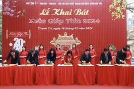Các đại biểu thành phố Hà Nội thực hiện nghi thức khai bút. (Ảnh: TTXVN phát)