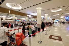 Hành khách làm thủ tục tại Sân bay Quốc tế Dubai. (Ảnh: AFP/TTXVN)