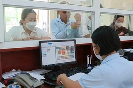Người dân đến đăng ký tham gia bảo hiểm y tế tại Bảo hiểm Xã hội huyện Lục Yên, tỉnh Yên Bái. (Ảnh: Việt Dũng/TTXVN)