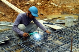 Công nhân làm xuyên Tết tại Dự án thành phần Vạn Ninh-Cam Lộ thuộc Dự án Cao tốc Bắc-Nam. (Ảnh: Tá Chuyên/TTXVN)