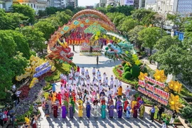 Hơn 5.000 người tham gia chương trình đồng diễn áo dài theo hướng dẫn của biên đạo múa Minh Nhật. (Ảnh: Thu Hương/TTXVN)