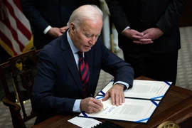 Tổng thống Mỹ Joe Biden ký phê chuẩn một dự luật tại Nhà Trắng ở Washington DC. (Ảnh: AFP/TTXVN)