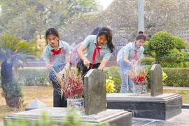 Các em học sinh dâng hương tưởng niệm, tri ân các anh hùng, liệt sỹ tại Nghĩa trang Liệt sỹ Quốc gia A1. (Ảnh: Xuân Tư/TTXVN)