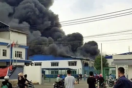 Đám cháy tại Công ty Trách nhiệm hữu hạn Xin Rong International tạo ra cột khói đen cao hàng chục mét. (Ảnh: TTXVN phát)