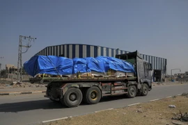Xe chở hàng viện trợ di chuyển trên tuyến đường ở miền Trung Dải Gaza ngày 21/5. (Ảnh: THX/TTXVN)
