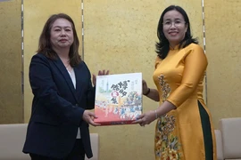 Phó Chủ tịch Ủy ban Nhân dân thành phố Đà Nẵng Nguyễn Thị Anh Thi (phải) nhận quà lưu niệm của bà Satomi Iwashige, Phó Hiệu trưởng Trường Đại học tỉnh Nagasaki. (Ảnh: Quốc Dũng/TTXVN)