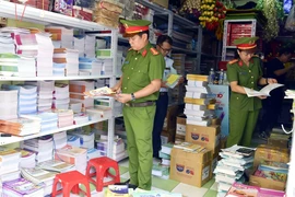 Lực lượng Cảnh sát Kinh tế (Công an tỉnh Quảng Bình) kiểm tra phát hiện hai cơ sở buôn bán sách, vở lậu trên địa bàn. (Ảnh: TTXVN phát)