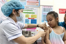 Nhân viên trạm Y tế phường An Lạc, quận Bình Tân tiêm vaccine phòng sởi cho trẻ. (Ảnh: Đinh Hằng/TTXVN)