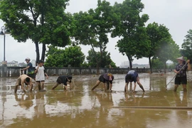 Người dân dọn dẹp vệ sinh sau khi nước rút tại Lào Cai. (Ảnh: Hồng Ninh/TTXVN)