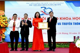 Giáo sư-Tiến sỹ Lê Văn Lợi, Phó Giám đốc Học viện Chính trị Quốc gia Hồ Chí Minh trao Bằng khen của Giám đốc Học viện Chính trị Quốc gia Hồ Chí Minh cho Tạp chí Lý luận Chính trị và Truyền thông.