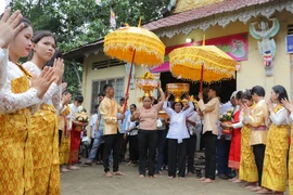 Đồng bào phật tử Khmer tiến hành nghi thức dâng y. (Ảnh: Nguyễn Hằng/TTXVN)