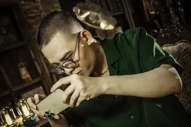 Đạo diễn Phạm Vĩnh Khương thực hiện các thao tác quay phim trên điện thoại. (Ảnh: TTXVN phát)