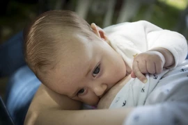 Em bé bú sữa mẹ. (Ảnh: AFP/TTXVN)