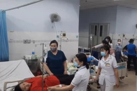 Công nhân Công ty TNHH Dechang (đóng tại Khu công nghiệp Giang Điền, huyện Trảng Bom, Đồng Nai) nhập viện sau bữa ăn tối với các triệu chứng nghi ngộ độc. (Ảnh: TTXVN Phát)
