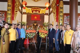 Đại sứ Phạm Việt Hùng, Tổng lãnh sự Chu Đức Dũng, cùng đại diện các hội kiều bào chụp ảnh lưu niệm trước ban thờ Bác Hồ. (Ảnh: Đỗ Sinh/TTXVN)