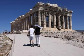 Du khách che ô tránh nắng nóng khi tham quan thành cổ Acropolis ở Athens, Hy Lạp, ngày 16/7. (Ảnh: Getty Images/TTXVN)