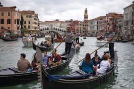 Du khách đi thuyền gondola tại Venice, Italy. (Ảnh: AFP/TTXVN)