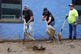 Người dân dọn bùn sau khi bão Helene quét qua ở Asheville, bang North Carolina, Mỹ. (Ảnh: Kyodo/TTXVN)