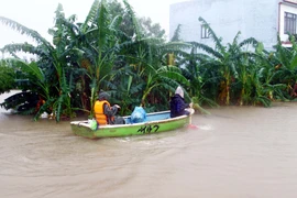 Người dân các địa phương huyện Lệ Thủy (Quảng Bình) dùng thuyền di chuyển trong vùng bị ngập lụt. (Ảnh: Tá Chuyên/TTXVN)