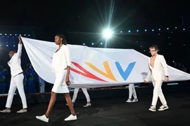 Các vận động viên mang cờ của Liên đoàn Đại hội thể thao Khối thịnh vượng chung trong lễ khai mạc Đại hội thể thao Khối thịnh vượng chung ở Birmingham, miền trung nước Anh, ngày 28/7/2022. (Ảnh: Andy Buchanan/AFP)