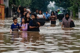 Người dân sơ tán khỏi khu vực ngập lụt ở thành phố Bandung, cách thủ đô Jakarta 180km về phía Đông. (Ảnh: AFP/TTXVN)