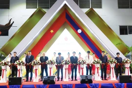 Đại sứ Việt Nam tại Lào Nguyễn Bá Hùng và các đại biểu cắt băng khai mạc triển lãm. (Ảnh: Xuân Tú/TTXVN)