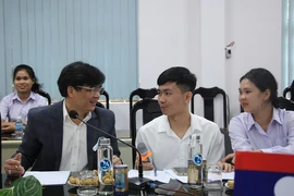 Ông Phan Phiến, Hiệu trưởng Trường Đại học Khánh Hòa trao đổi cùng hai du học sinh Lào, học năm thứ 2 tại Trường. (Ảnh: Phan Sáu/TTXVN)