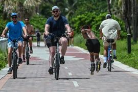 Đi bộ hoặc đạp xe là lựa chọn di chuyển "xanh" nhất. (Ảnh: AFP/TTXVN)