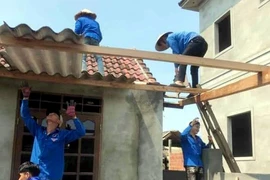 Đoàn thanh niên giúp người dân lợp lại nhà cửa sau lốc lốc xoáy tại Hà Tĩnh. (Ảnh: Công Tường/TTXVN)