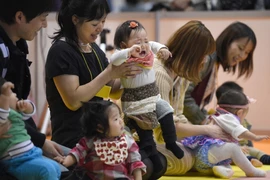 Cha mẹ cùng các em bé tham gia một cuộc thi ở Tokyo (Nhật Bản). (Ảnh: AFP/TTXVN)