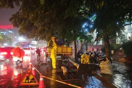 Các đơn vị ứng trực thoát nước ở khu vực đường Minh Khai, quận Hai Bà Trưng trong trận mưa lớn tối 12/5. (Ảnh: TTXVN)