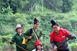 Học sinh bản Phiêng Nghè (Sơn La) được phụ huynh chở bằng bè tre để đến dự Lễ khai giảng năm học mới. (Ảnh: Quang Quyết/TTXVN)