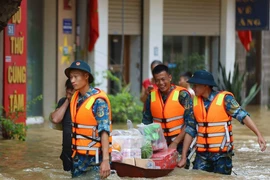 Lực lượng Quân đội, Công an, dân quân giúp dân xã Bát Tràng, huyện Gia Lâm (Hà Nội) di chuyển ra khỏi vùng ngập lụt. (Ảnh: Thanh Tùng/TTXVN)