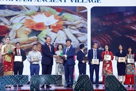 Bộ trưởng Bộ Văn hóa-Thể thao và Du lịch Việt Nam Nguyễn Văn Hùng trao Giải thưởng Du lịch ASEAN 2024 cho đại diện Làng cổ Đường Lâm. (Ảnh: Phạm Kiên/TTXVN)