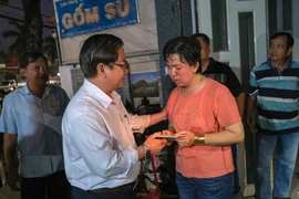 Chủ tịch UBND thành phố Cần Thơ Trần Việt Trường thăm hỏi, trao tiền hỗ trợ cho đại diện Cơ sở sửa chữa, mua bán phụ tùng ôtô Kim Thu. (Ảnh: Thanh Liêm/TTXVN)