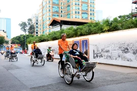 Khách quốc tế tham quan trung tâm Thành phố Hồ Chí Minh bằng xích lô. (Ảnh: Hồng Đạt/TTXVN)